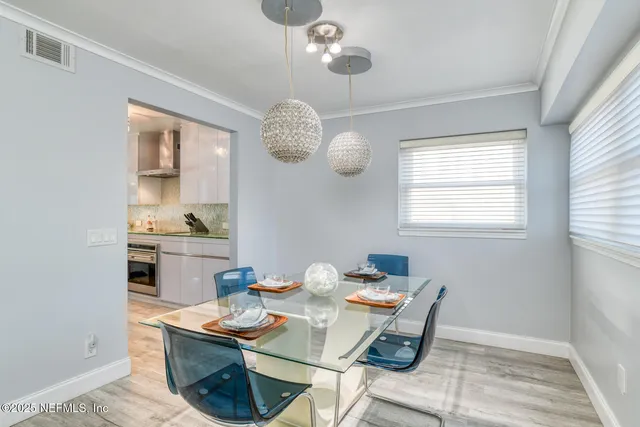 a view of a dining room with a table and chairs