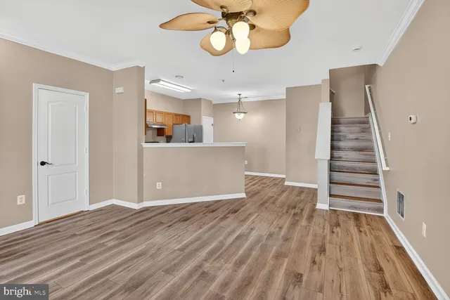 a view of an empty room with wooden floor and entryway