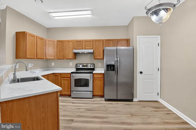a kitchen with granite countertop a refrigerator stove and sink
