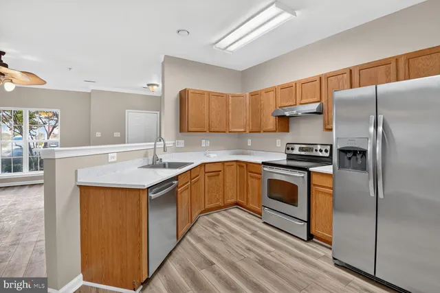 a kitchen with stainless steel appliances granite countertop a refrigerator a sink and a stove