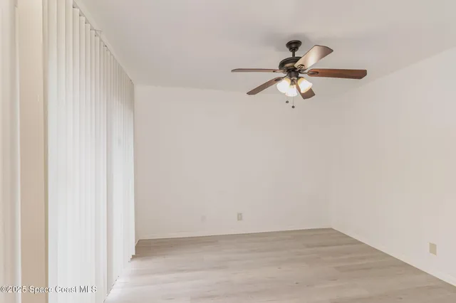 a view of a chandelier fan and hardwood floor