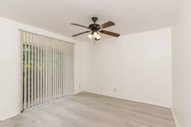 a view of a room with a ceiling fan and a window