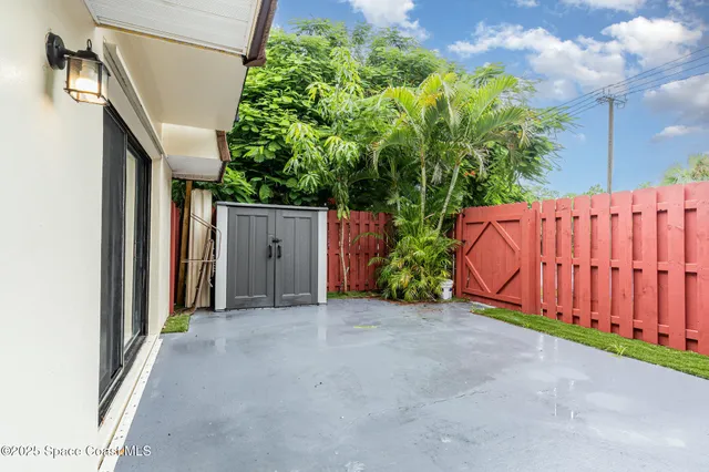 a view of a house with a backyard and bushes