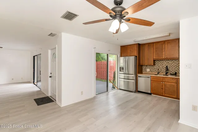 a kitchen with stainless steel appliances kitchen island granite countertop a refrigerator and a stove top oven