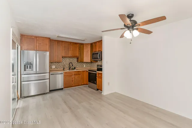 a kitchen with a refrigerator and white cabinets