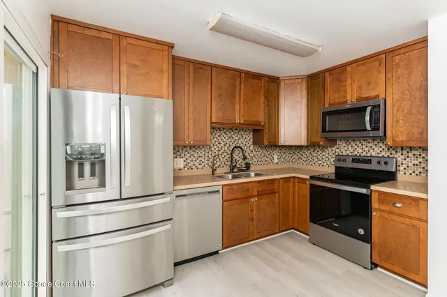 a kitchen with stainless steel appliances granite countertop a refrigerator sink and stove