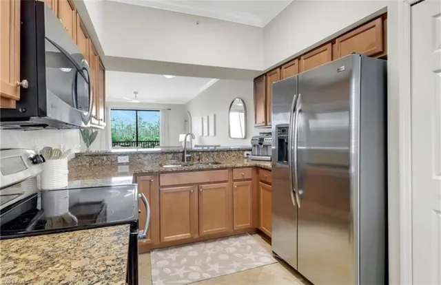 a kitchen with stainless steel appliances granite countertop a refrigerator and a sink