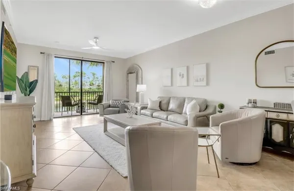 a living room with furniture a large window and potted plants