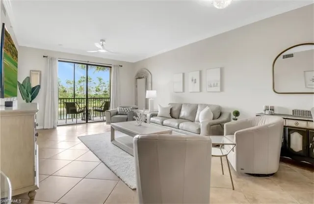 a living room with furniture a large window and potted plants