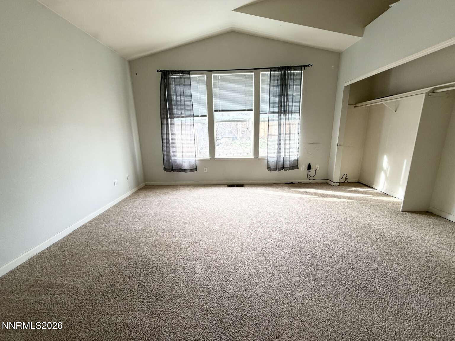 4695 Hampton Lane Reno, NV 89519 - Photo 6 of 20 an empty room with a fireplace and windows