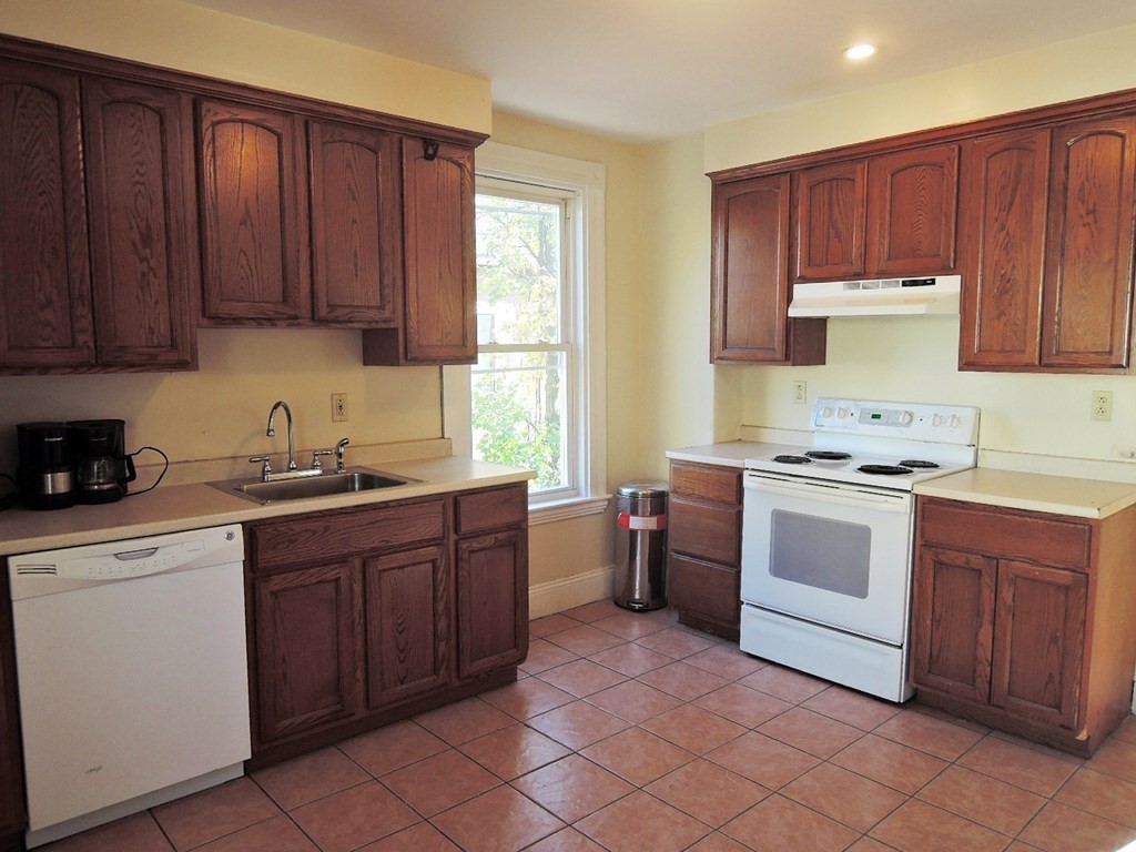 a kitchen with sink a stove and cabinets