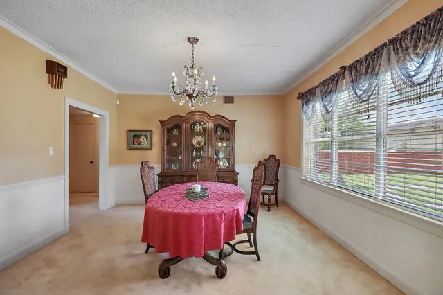 a dining room with furniture a chandelier and window