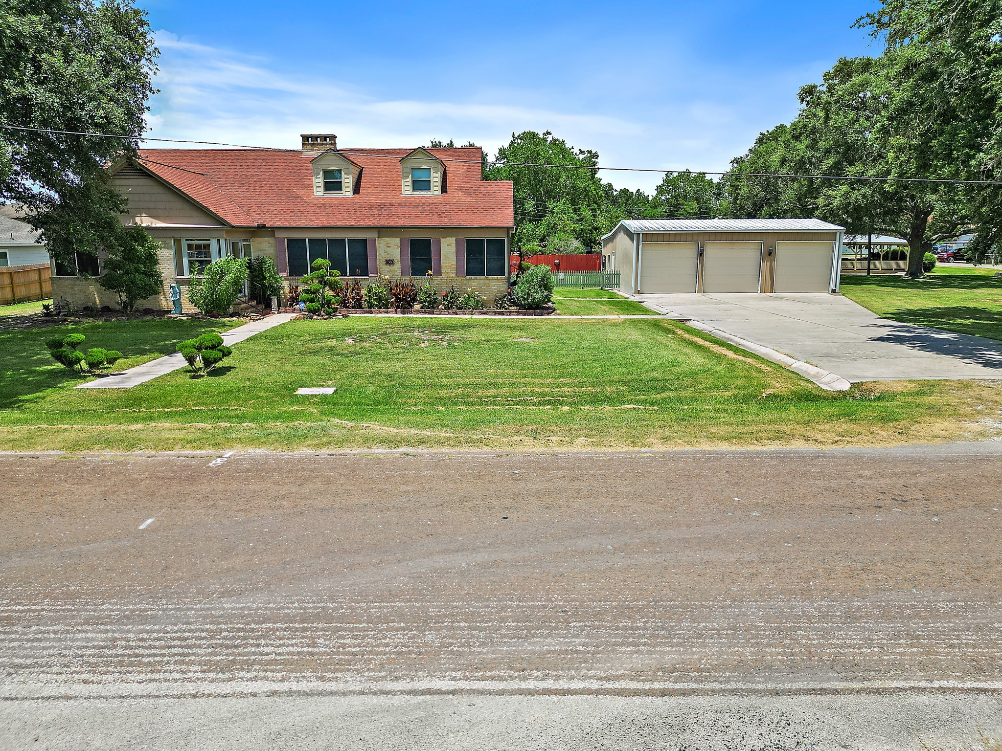 405 Park Street Anahuac, TX 77514 - Photo 2 of 37 a front view of a house with a yard and potted plants