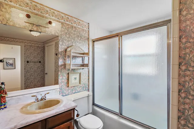 a bathroom with a sink toilet a mirror and shower