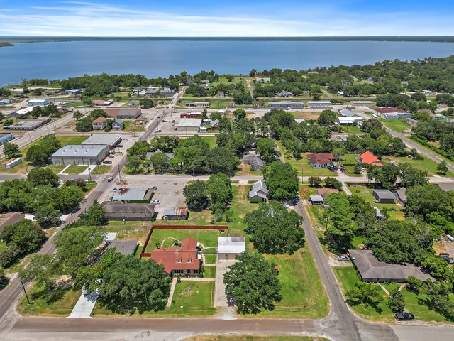 an aerial view of residential houses with outdoor space and ocean view