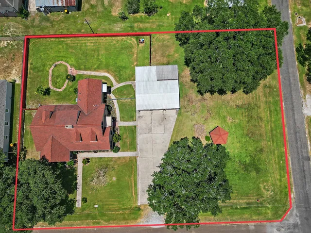 an aerial view of a house with a garden and trees