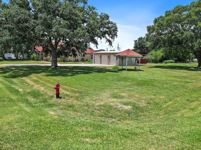 a view of a house with a yard and tree s