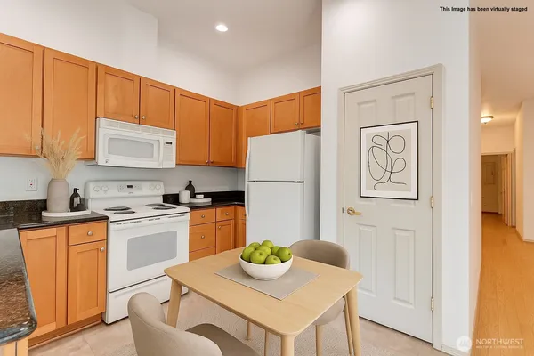 a kitchen with a refrigerator a stove a sink and a dining table