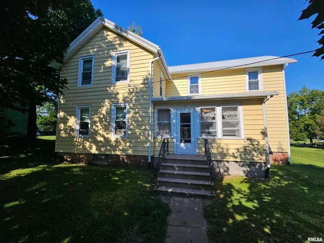 a front view of house with a garden