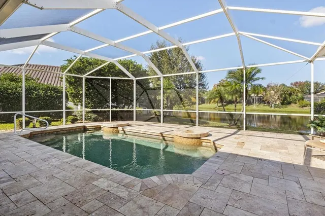 a view of a lake with a yard and large trees