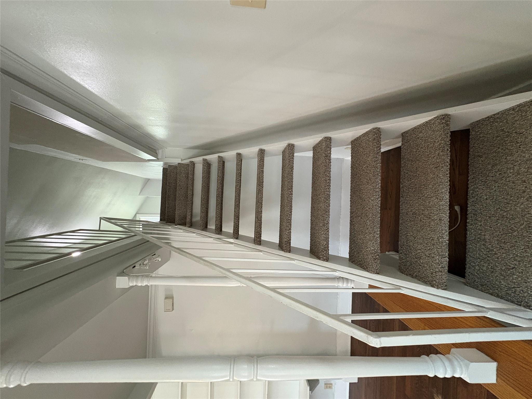 915 West 29th Street Austin, TX 78705 - Photo 15 of 20 Carpeted staircase with white balusters and handrail, featuring a partial banister
