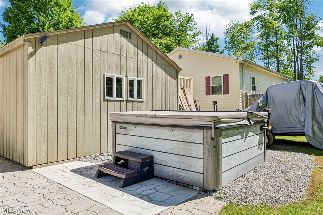 2960 Rome Rock Creek Road Rock Creek, OH 44084 - Photo 44 of 49 Outdoor spa with composite siding and a protective cover, situated on a paver patio