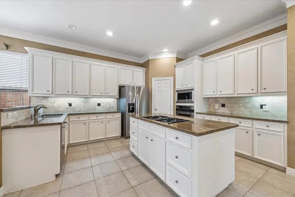 a kitchen with a stove top oven and refrigerator