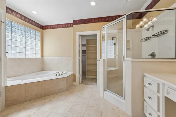 a spacious bedroom with a balcony a bed and a chandelier