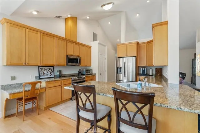a kitchen with stainless steel appliances granite countertop a refrigerator a stove top oven a sink and dishwasher