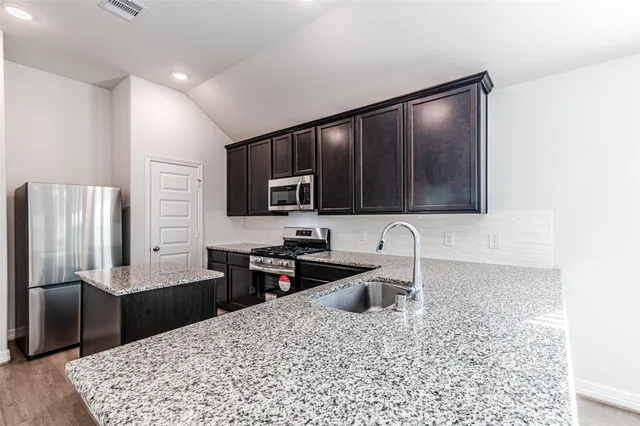 a kitchen with stainless steel appliances granite countertop a sink and stove