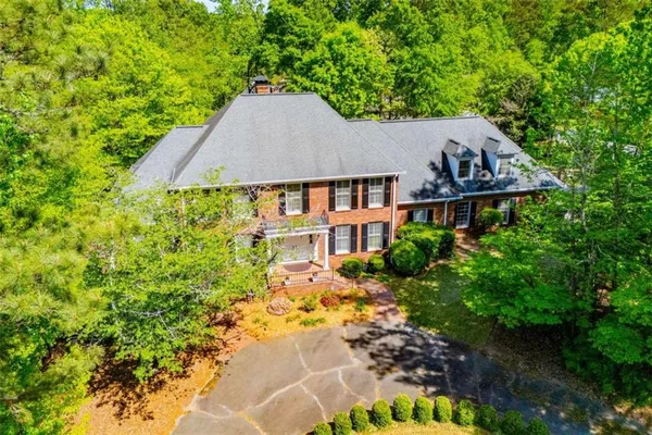 a kitchen with stainless steel appliances granite countertop a stove a sink dishwasher a dining table and chairs with wooden floor