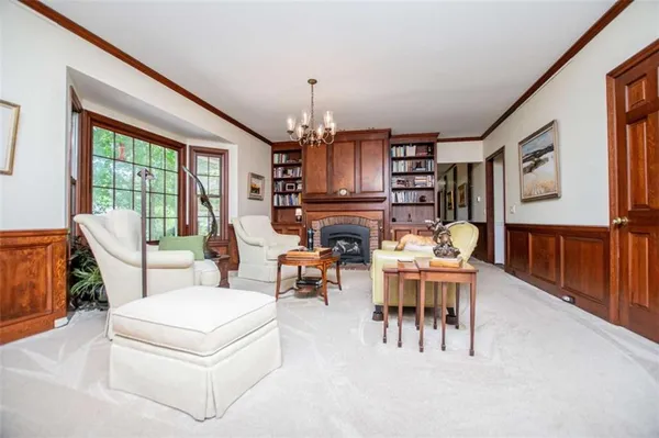 a living room with furniture a large window and bookshelf