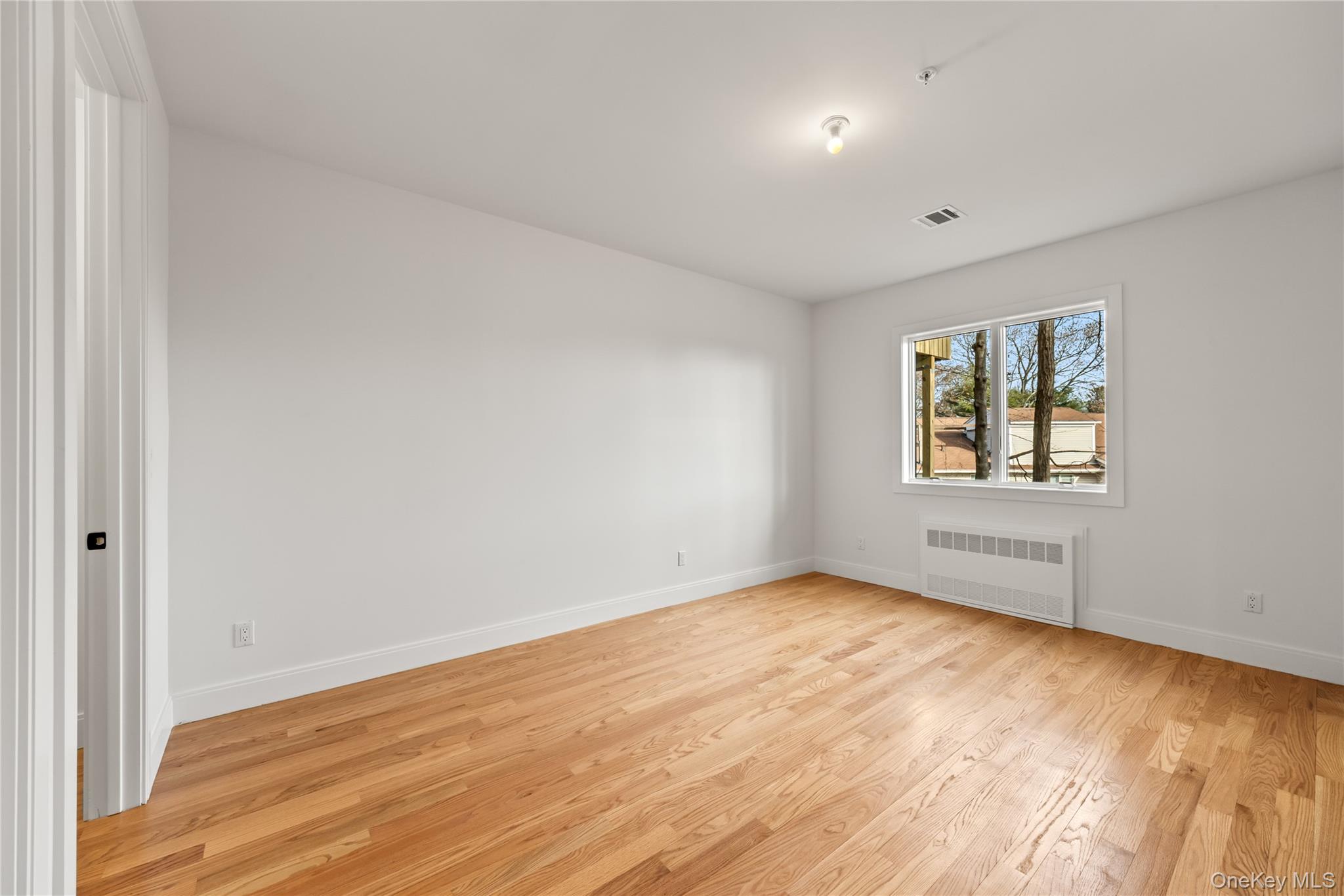 5 Jeffrey Place, Unit 102 Monsey, NY 10952 - Photo 11 of 23 an empty room with wooden floor and windows