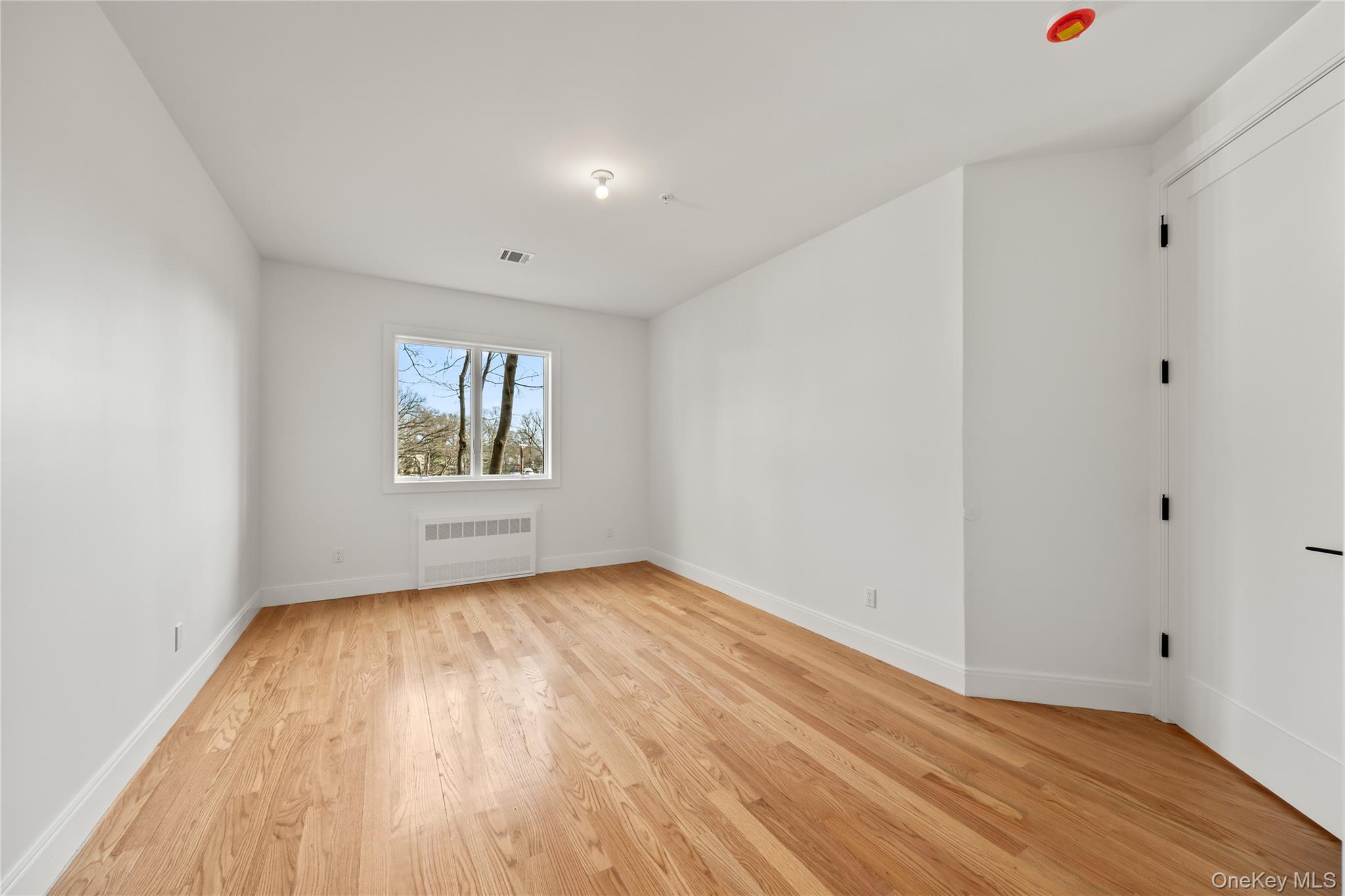 5 Jeffrey Place, Unit 102 Monsey, NY 10952 - Photo 12 of 23 a view of an empty room with wooden floor and a window