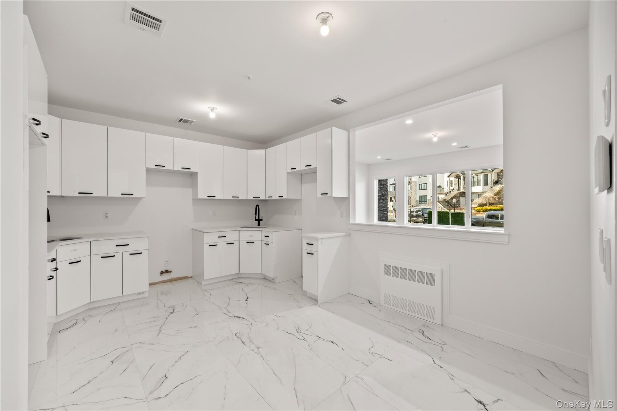 5 Jeffrey Place, Unit 102 Monsey, NY 10952 - Photo 7 of 23 a kitchen with white cabinets and sink
