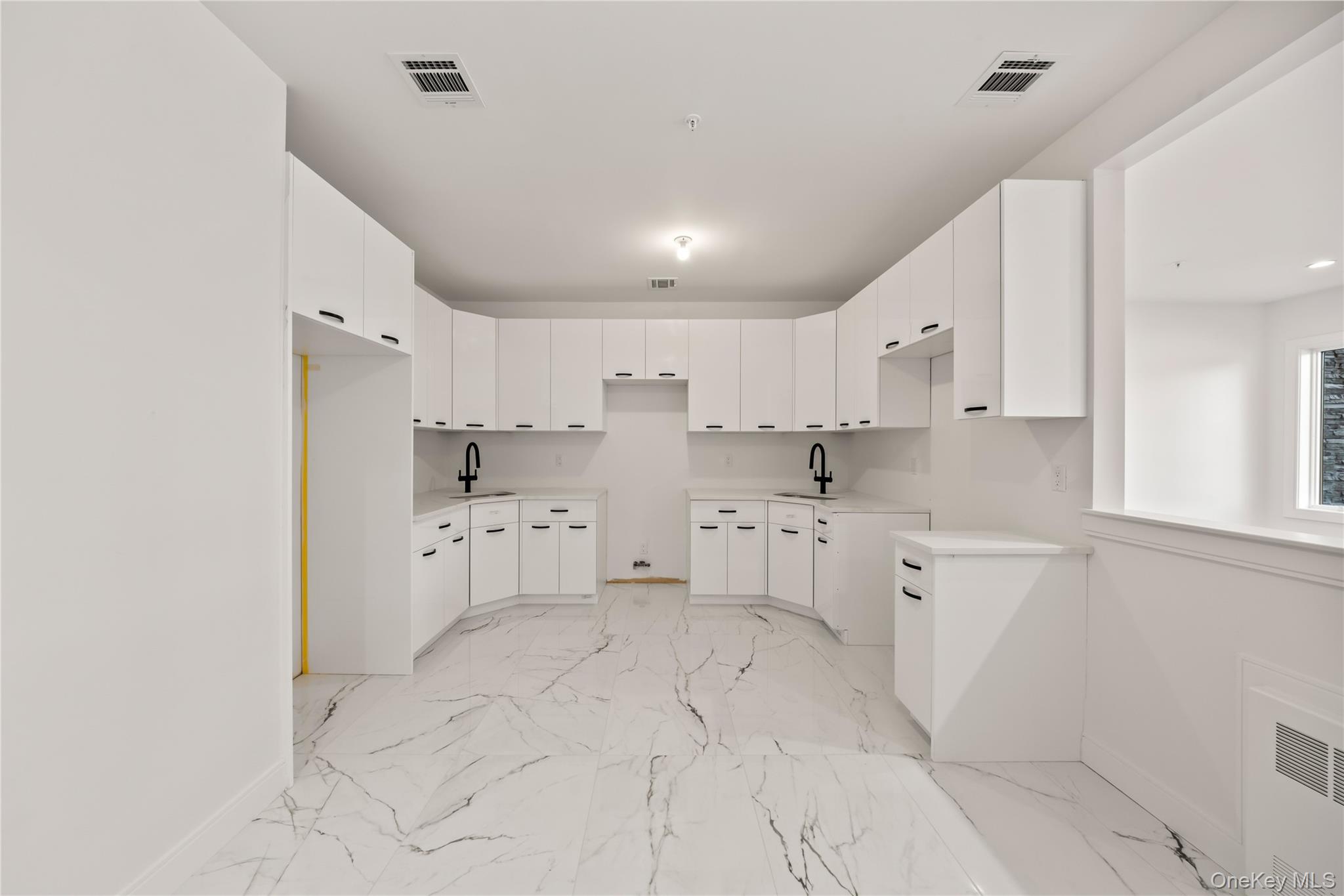 5 Jeffrey Place, Unit 102 Monsey, NY 10952 - Photo 8 of 23 a kitchen with white cabinets and white appliances