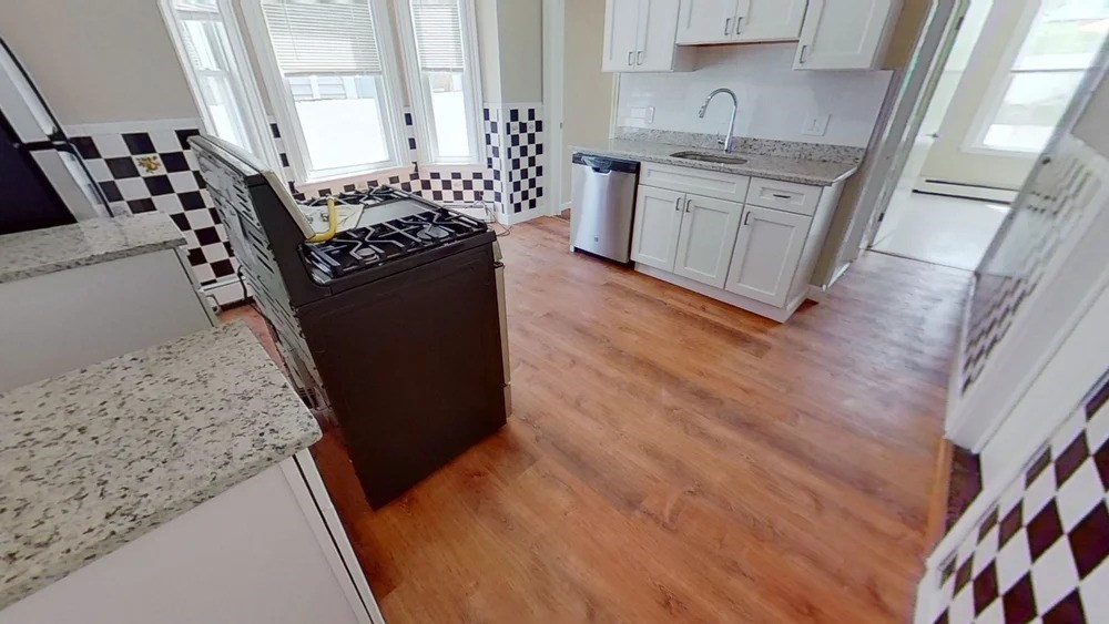 121 George Street, Unit 1 Boston, MA 02119 - Photo 3 of 7 a kitchen with granite countertop a stove and cabinets