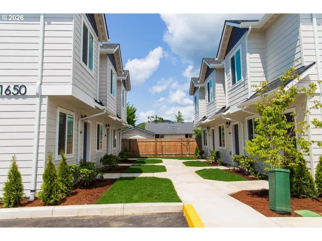 a view of a brick building next to a yard