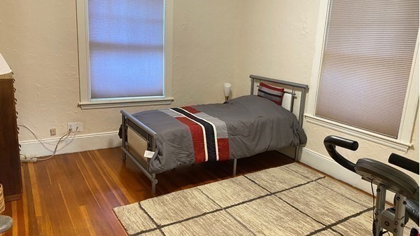 111 University Road Brookline, MA 02445 - Photo 12 of 17 a bedroom with a bed a mirror and a window