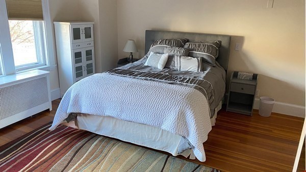 111 University Road Brookline, MA 02445 - Photo 9 of 17 a bedroom with a bed and wooden floor