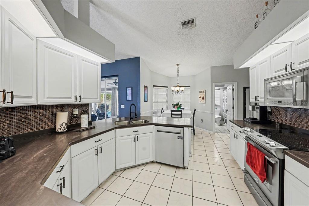 2583 Running Oak Court Spring Hill, FL 34608 - Photo 4 of 13 a kitchen with a sink stove and cabinets