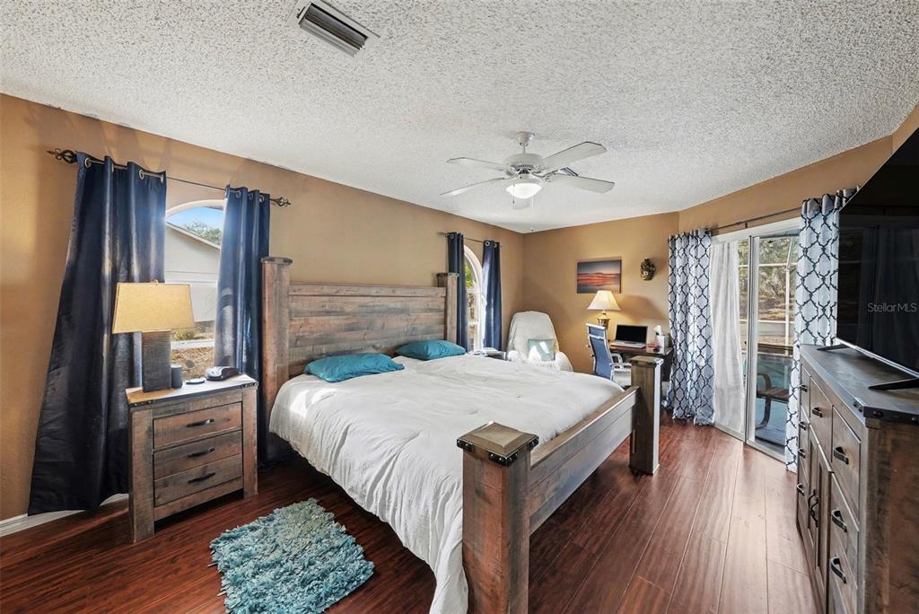 2583 Running Oak Court Spring Hill, FL 34608 - Photo 6 of 13 a bedroom with a bed a dresser and wooden floor