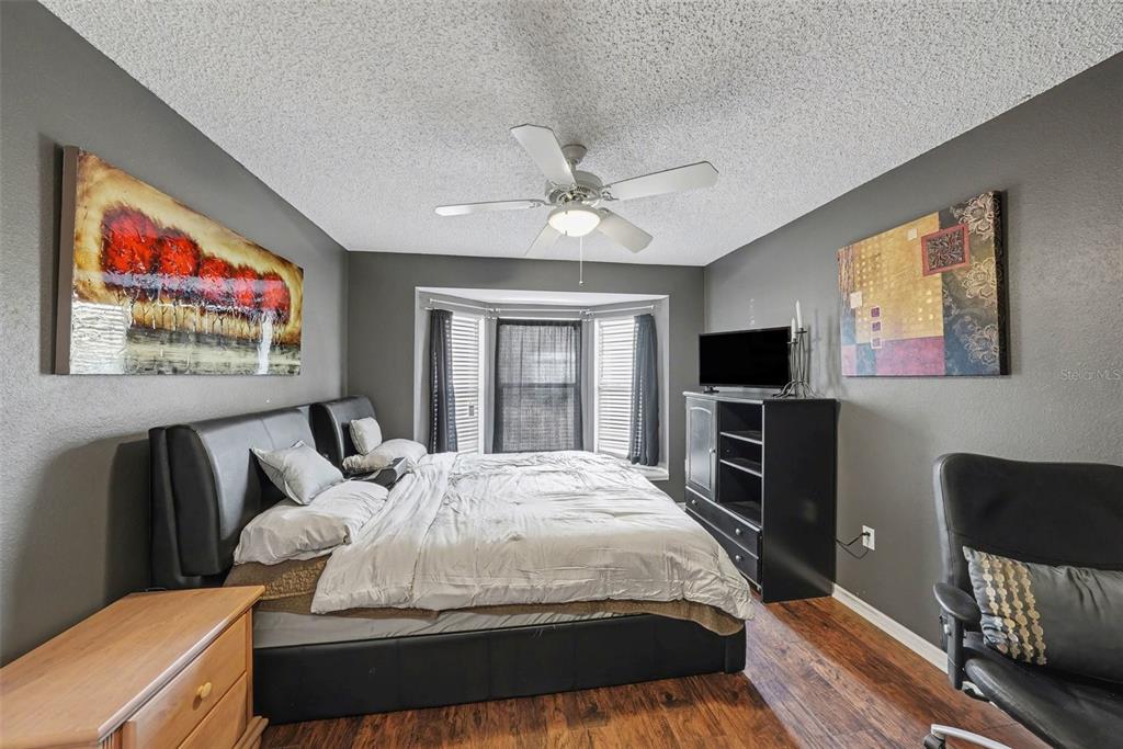 2583 Running Oak Court Spring Hill, FL 34608 - Photo 7 of 13 a spacious bedroom with a bed and a flat screen tv