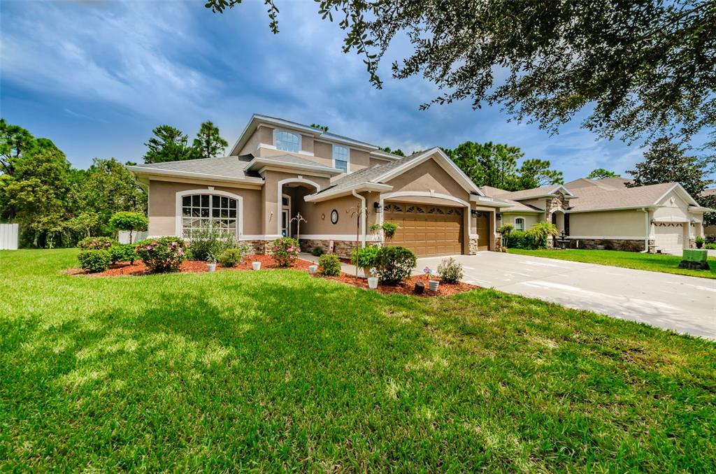 4599 Birchfield Loop Spring Hill, FL 34609 - Photo 1 of 1 a front view of a house with a garden