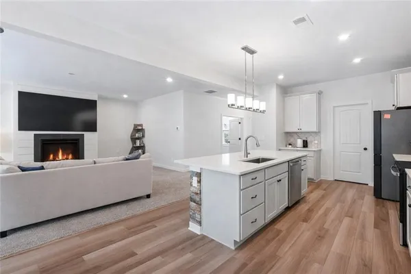 a kitchen with kitchen island sink stove and refrigerator