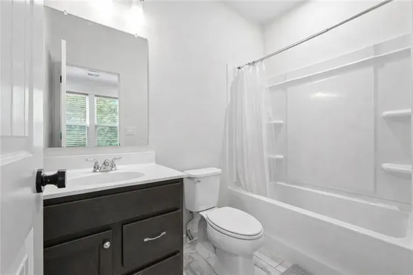 a bathroom with a double vanity sink toilet mirror and shower