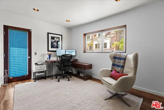 a view of a livingroom with workspace and a window