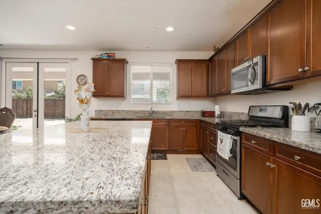 a kitchen with stainless steel appliances granite countertop a stove sink and cabinets