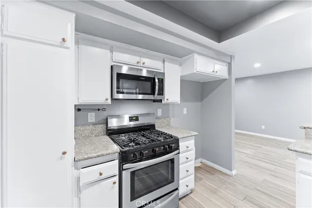 a kitchen with stainless steel appliances granite countertop a stove microwave and sink