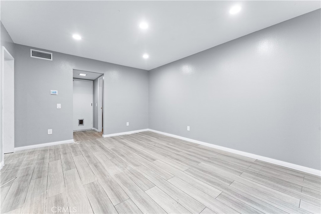 83 Weepingwood, Unit 35 Irvine, CA 92614 - Photo 6 of 19 an empty room with wooden floor and windows